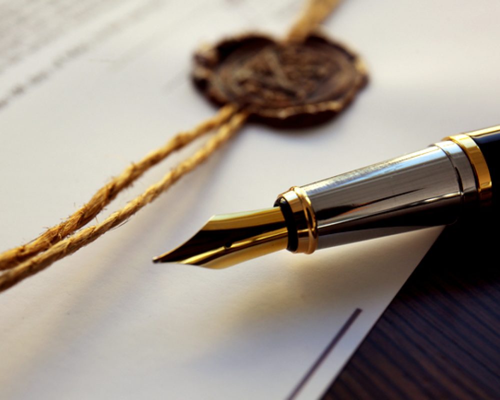 Fountain pen and old notarial wax seal on document, closeup